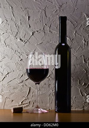 bottle and glass with red wine on a background of old wall Stock Photo