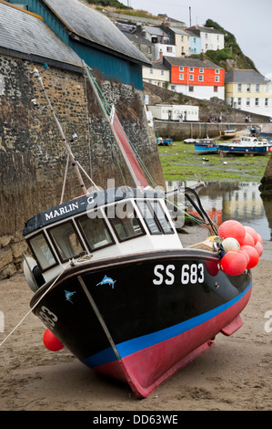 Vertical close up view of a small fishing trawler in Mevagissey harbour at low tide.