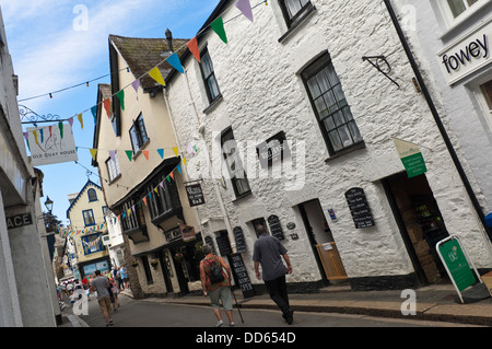 Horizontal view of people walking down a narrow street in Fowey on a sunny day. Stock Photo