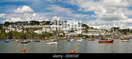 Horizontal panoramic view of Fowey with numerous boats moored in the estuary. Stock Photo