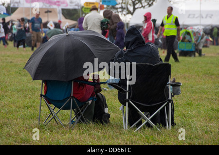 Horizontal view of people at a music festival in the pouring rain. Stock Photo