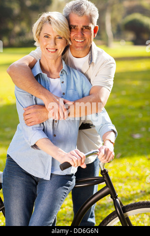 beautiful middle aged couple on bike outdoors Stock Photo