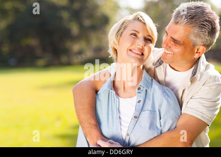 cute middle aged couple embracing outdoors Stock Photo