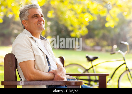 handsome middle aged man sitting at the park Stock Photo