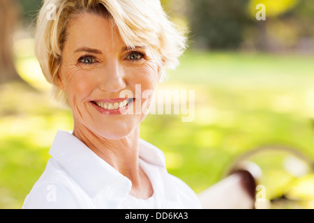 elegant mature woman sitting outdoors Stock Photo