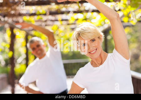 active senior woman exercising with husband outdoors Stock Photo