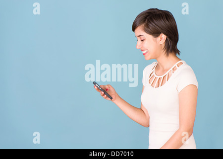 Happy and carefree young woman reading text message on cell phone Stock Photo
