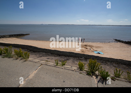 Canvey island Essex UK sea defences defenses with people on beach Stock Photo