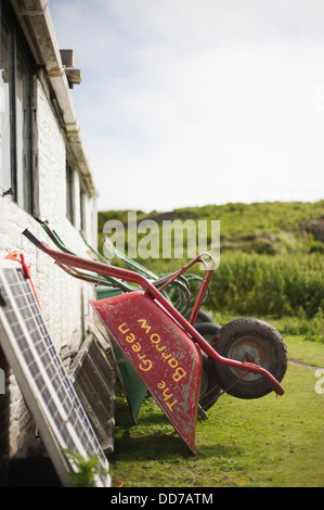 Line of wheelbarrows resting against a wall, Skokholm Island, Wales, United Kingdom Stock Photo