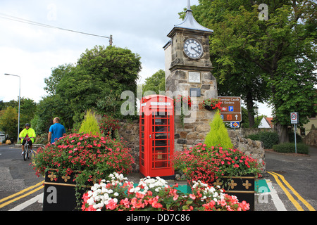 Colourful flowers at the clock at the top of the high street in Aberdour one of Fife's coastal towns Stock Photo