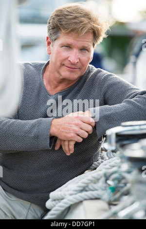 Caucasian man sitting on sailboat Stock Photo