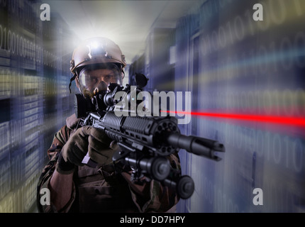 Soldier holding gun in server room Stock Photo