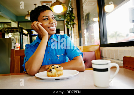 African American woman smiling in restaurant Stock Photo