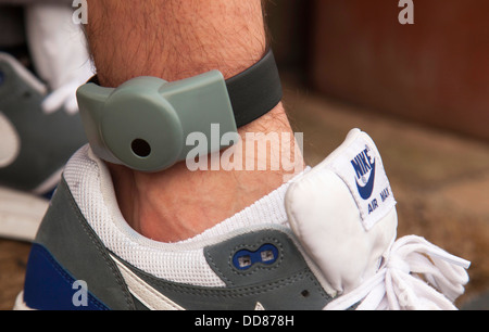 An electronic ankle tag on a teenage offender in the U.K. (identification number obscured). Stock Photo