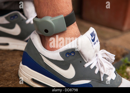 An electronic ankle tag on a teenage offender in the U.K. (identification number obscured). Stock Photo