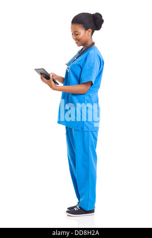 side view of happy African American nurse using tablet computer on white background Stock Photo