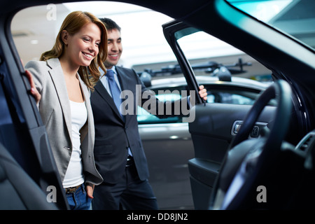 Dealer showing a new car model to the potential customer Stock Photo