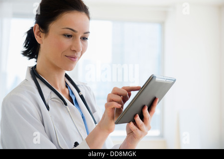 Caucasian doctor using tablet computer Stock Photo
