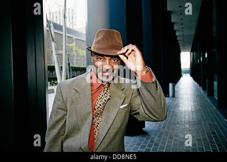 Black businessman tipping his hat Stock Photo