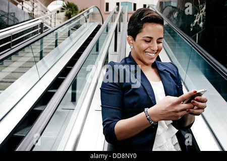 Hispanic businesswoman using cell phone Stock Photo