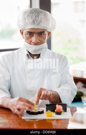 Hispanic chef preparing sushi in restaurant Stock Photo
