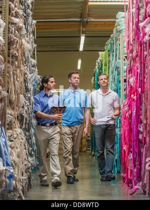 Workers examining fabric in textile factory Stock Photo