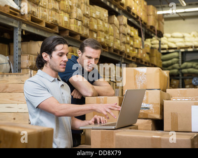 Workers using laptop in textile factory Stock Photo