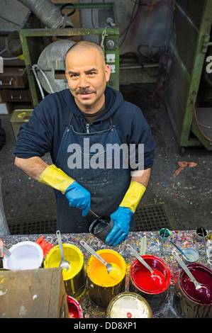 Hispanic worker mixing paint in workshop Stock Photo