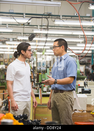 Workers talking in textile factory Stock Photo