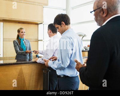 Business people in line at airport front desk Stock Photo