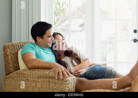 Couple relaxing together in armchair Stock Photo
