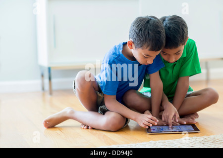 Boys using digital tablet on floor Stock Photo