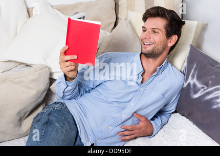 Young Brunette Man in Blue Shirt Reading A Book Stock Photo
