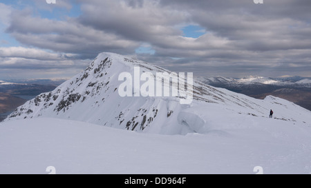 View towards the snowy mountain summit of Spidean Mialach in the Glenquoich Forest with Loch Loyne in the distance, Scotland UK Stock Photo