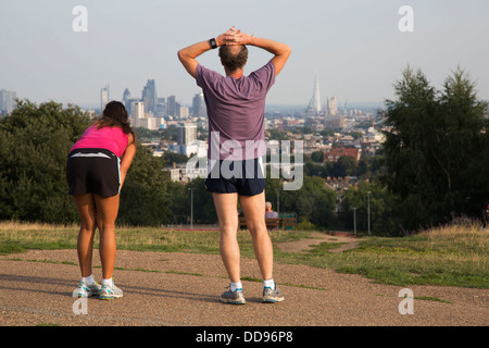 Runners on top of Parliament Hill with an amazing view towards the City of London from Hampstead Heath, London, UK. Stock Photo