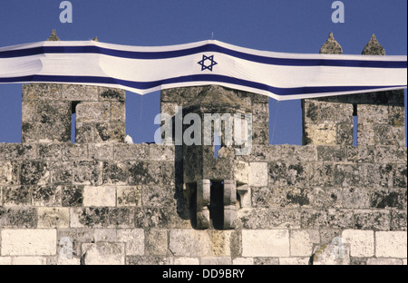 Israeli national flag on top of old city walls during Jerusalem Day celebrations East Jerusalem Israel Stock Photo