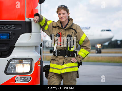 Fire officer of the fire department of Frankfurt airport, Angelina Franz, stands next to a fire engine on the premises of the Rhine-Main airport in Frankfurt, Germany, 13 August 2013. Franz is one of altogether six women who have joined the fire department at Germany's largest airport. Photo: Frank Rumpenhorst Stock Photo