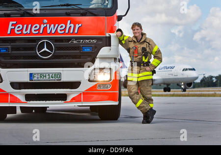 Fire officer of the fire department of Frankfurt airport, Angelina Franz, stands next to a fire engine on the premises of the Rhine-Main airport in Frankfurt, Germany, 13 August 2013. Franz is one of altogether six women who have joined the fire department at Germany's largest airport. Photo: Frank Rumpenhorst Stock Photo