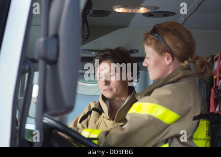 Fire officer of the fire department of Frankfurt airport, Annette Rueckert (L) sits next to her colleague Angelina Franz, in a  fire engine on the premises of the Rhine-Main airport in Frankfurt, Germany, 13 August 2013. Franz and Rueckert are two of altogether six women who have joined the fire department at Germany's largest airport. Photo: Frank Rumpenhorst Stock Photo