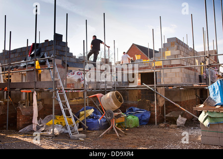 self building house, constructing upper floor, with traditional concrete block construction from first lift scaffolding Stock Photo