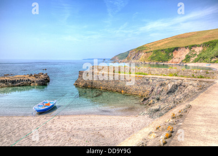 Single wooden dinghy moored in harbour in clear blue sea Portwrinkle Cornwall in HDR in England Stock Photo