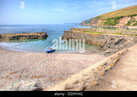 Tiny harbour Portwrinkle Cornwall with single rowing boat and blue sea in HDR Stock Photo