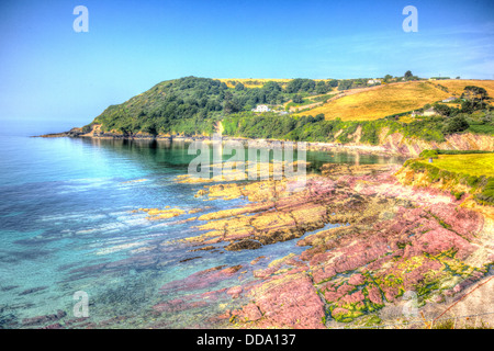 Coast of Cornwall bay with red rock and vivid colours at Talland Bay in HDR Stock Photo