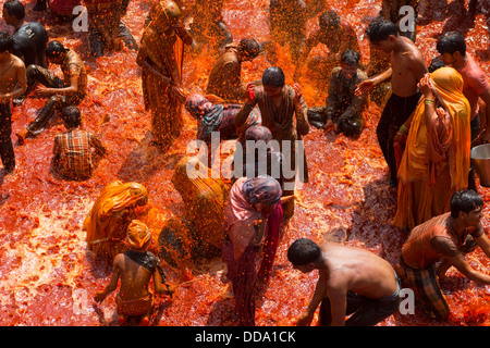 A group of people playing with the water stored inside the temple after the celebration of Holi in Baldeo. Stock Photo