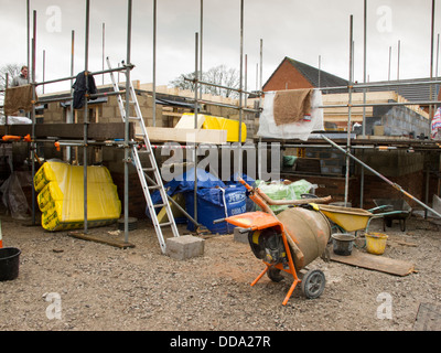 self building house, constructing upper floor, with traditional concrete block construction from first lift scaffolding Stock Photo