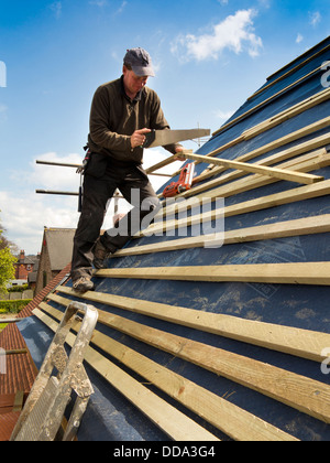 self building house, constructing roof, worker fixing wooden battens Stock Photo