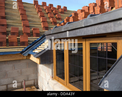 self building house, constructing roof, clay tiles stacked on wooden battens ready to be laid Stock Photo