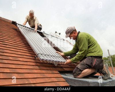 self building house, Installing Veissmann solar thermal hot water heating tubes on new build roof Stock Photo