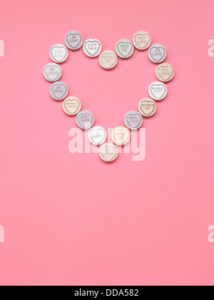 Love hearts positioned in the shape of a heart on a pink background Stock Photo