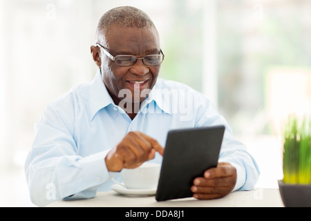 cheerful senior African American man using tablet computer at home Stock Photo
